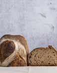 A cut loaf of sourdough bread of a table.