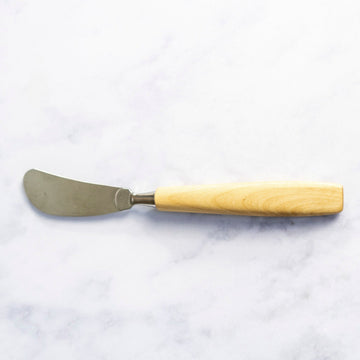 A wooden handled butter knife on a marble worktop.