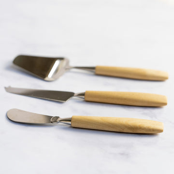 A set of bjorklund cheese knives on a marble worktop.