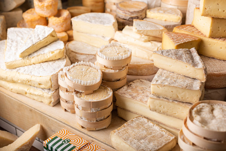 Various cuts and whole pieces of soft cheese on the shop counter
