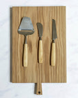 A selection of Bjorklund cheese knives on a wooden board.