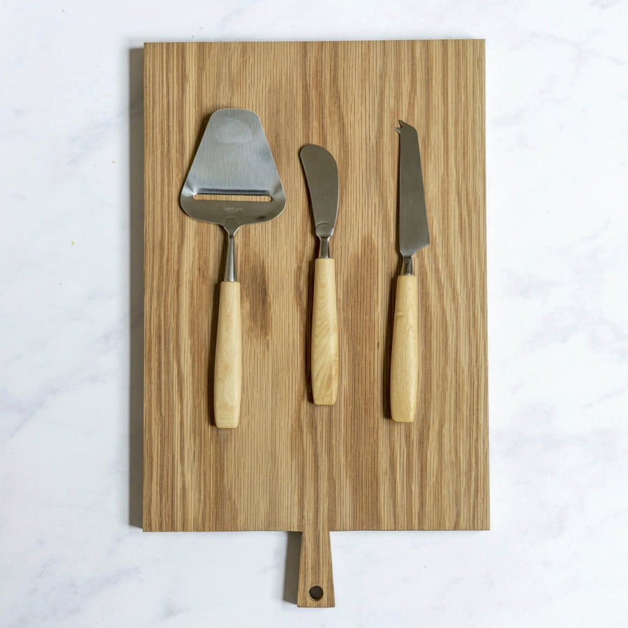 A selection of Bjorklund cheese knives on a wooden board.