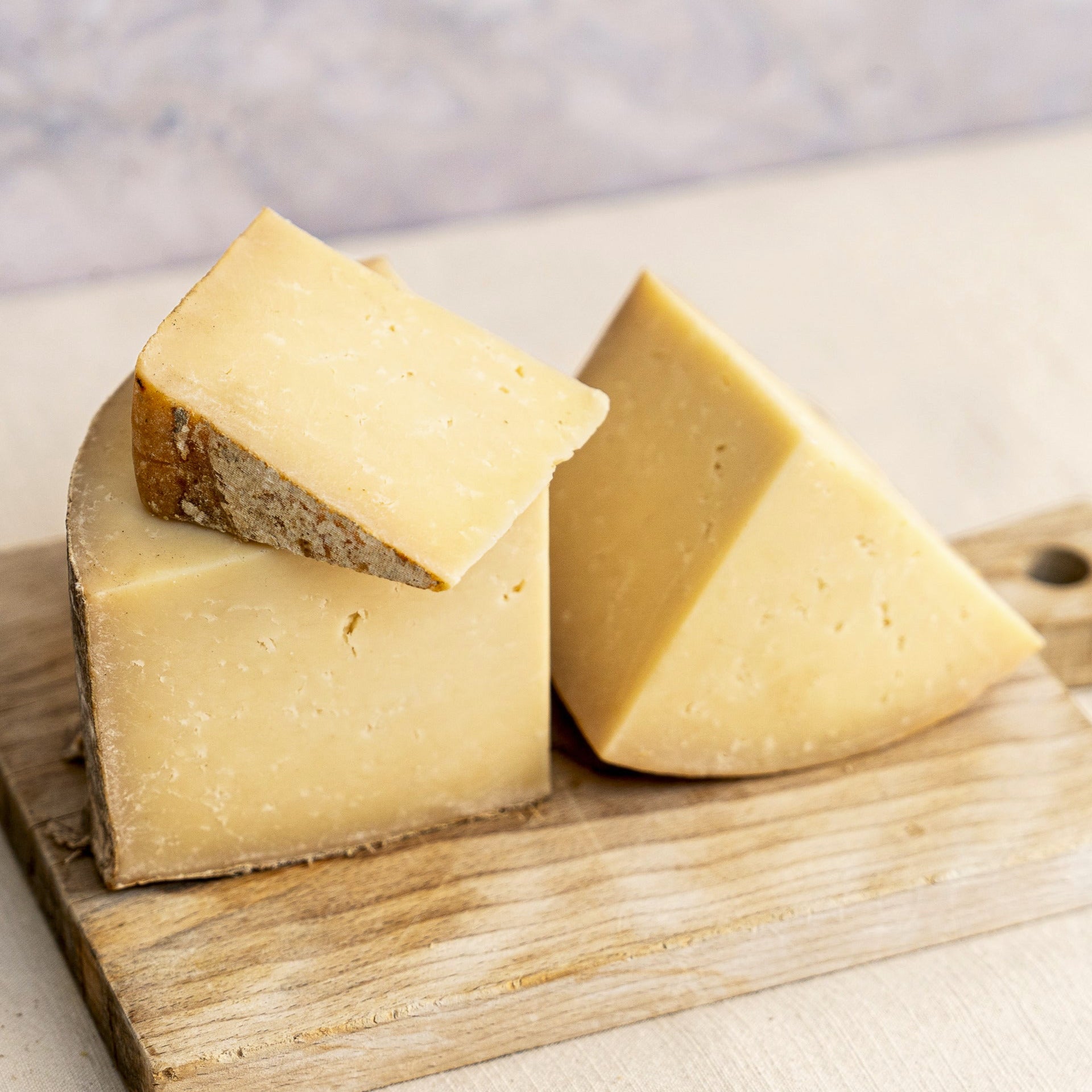 Cut pieces of Corra Linn cheese on a wooden board.