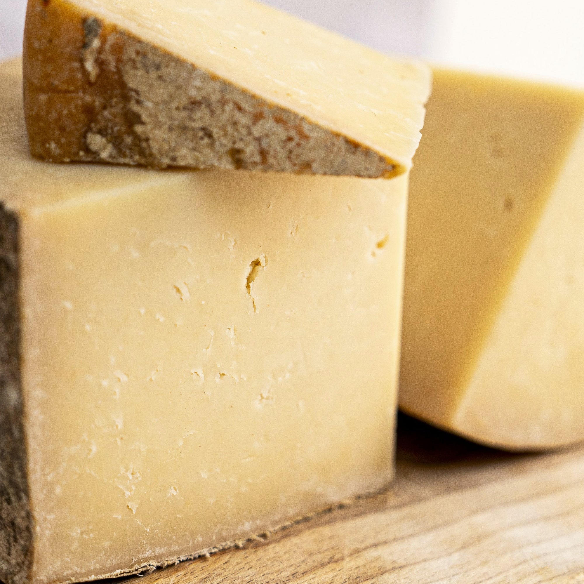 A close up of large cuts of Corra Linn cheese on a wooden board.