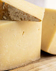 A close up of large cuts of Corra Linn cheese on a wooden board.