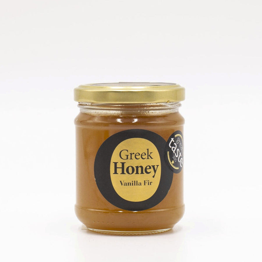 A glass jar of Greek Vanilla Fir Honey on a white background.