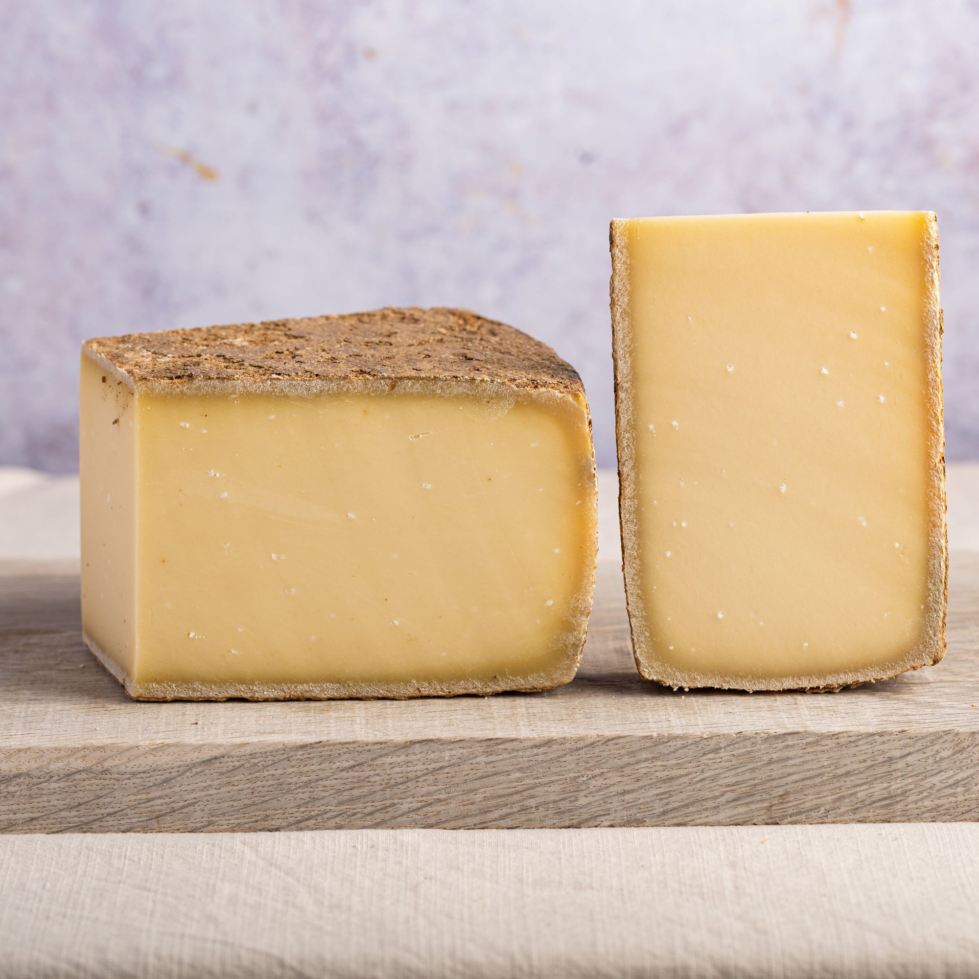 Pieces of cut cheese on a wooden board.