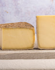 Pieces of cut cheese on a wooden board.