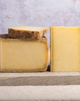 Pieces of cut cheese on a wooden board.
