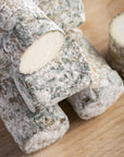 Close up of Oiselliere French goat's cheese on a wooden board.