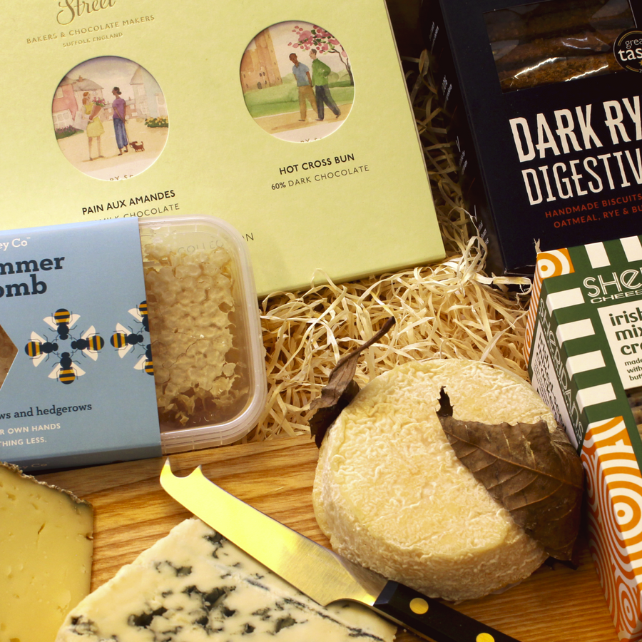 A selection of cheese, chocolates, biscuits and honey.