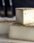 Cut pieces of Tinto hard goat's milk cheese on a wooden board.