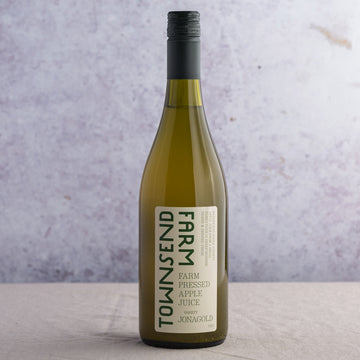 A 75cl green glass bottle of apple juice.