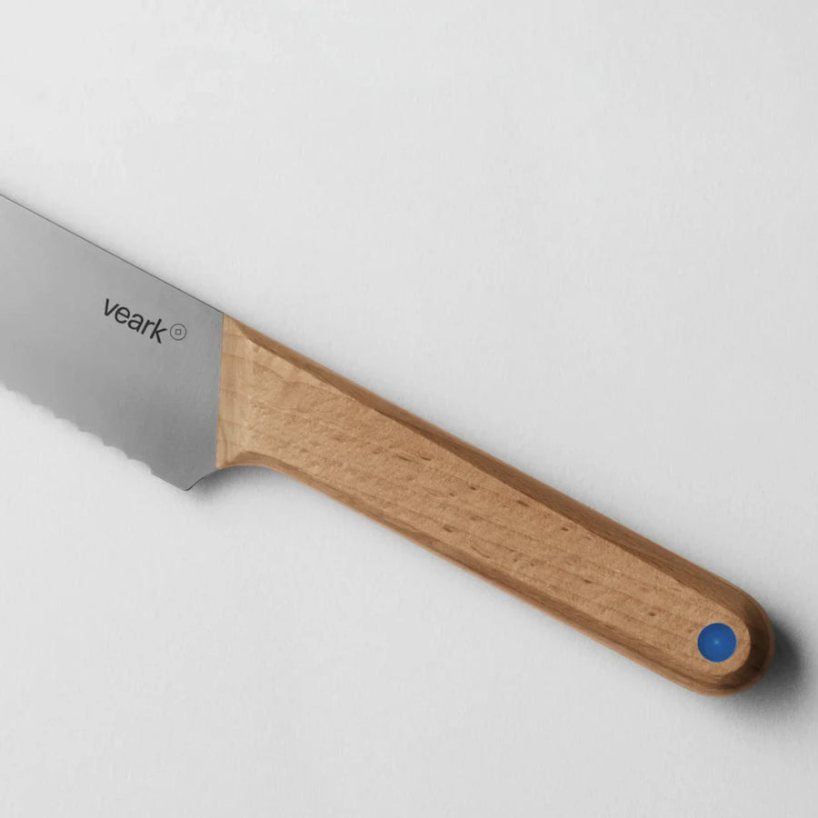 A close up of the birch handle of a Veark bread knife.