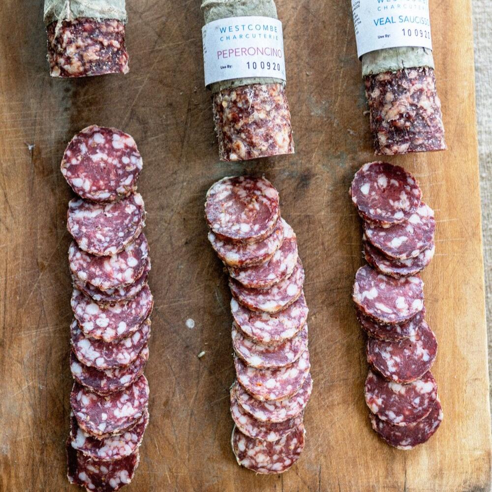 A selection of sliced salami on a wooden board.
