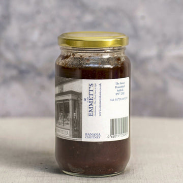 A large jar of deep red coloured banana chutney.