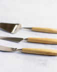 A set of bjorklund cheese knives on a marble worktop.