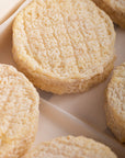Close up of the creamy coloured wrinkly rind of Brefu Bach ewe's milk cheese.