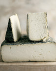 Cut pieces of Tomme de Chambrouze goat's cheese.