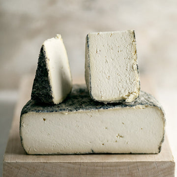 Cut pieces of Tomme de Chambrouze goat's cheese.