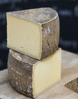 Cuts of Le Marechal hard cow's milk cheese on a wooden board.