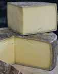 Various sized cuts of Le Marechal hard cow's milk cheese on a wooden board.