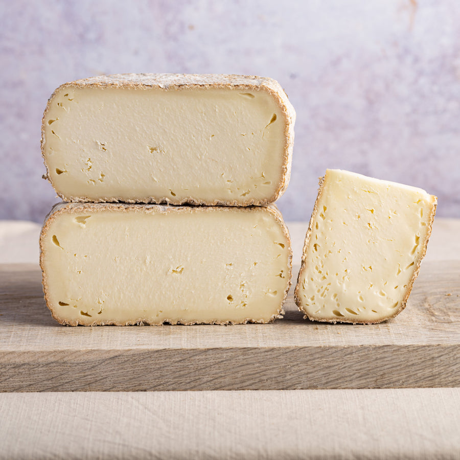 Cut pieces of pecorino ewe's milk cheese on a wooden board.
