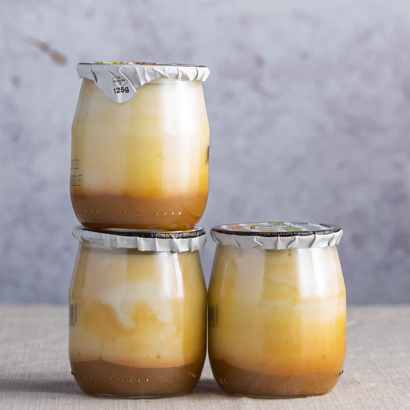 Glass jars of organic mirabelle plum compote yoghurt.