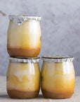 Glass jars of organic mirabelle plum compote yoghurt.