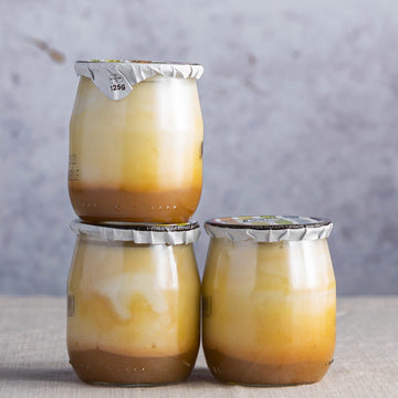 Glass jars of organic mirabelle plum compote yoghurt.