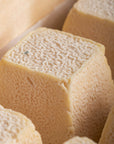 A close up of the wrinkly, slightly pink-coloured rind of a Sinodun Hill goat's cheese.