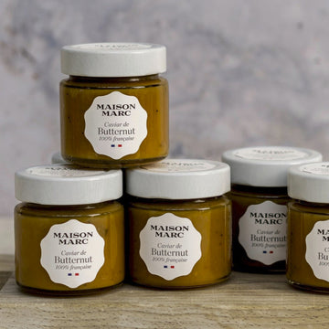 Jars of maison marc tapenade of butternut on a wooden board.