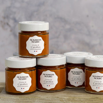 Jars of maison marc tapenade of carrot on a wooden board.