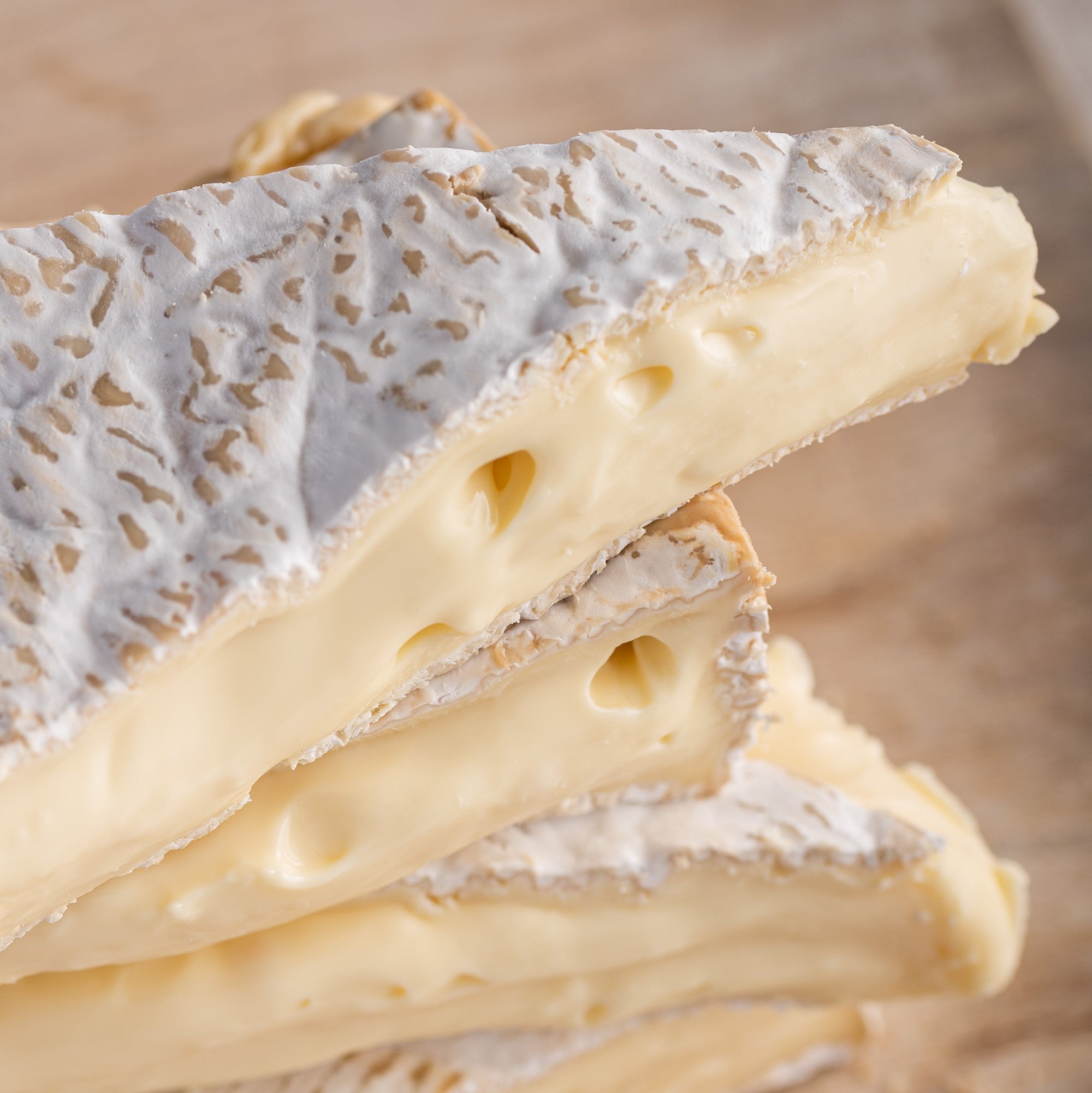 Close up of the oozing cut side of pieces of Brie soft cheese.
