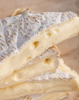 Close up of the oozing cut side of pieces of Brie soft cheese.