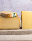 Cuts of Comte cheese on a wooden board.