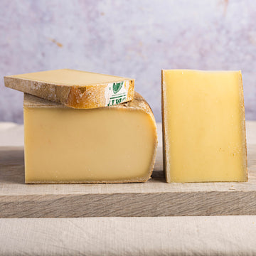 Cuts of Comte cheese on a wooden board.