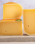 Cut pieces of Coolea cheese on a wooden board.