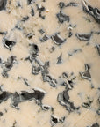 Detailed shot of Fourme d'Ambert cheese showing the rich blue veining and creamy white paste.