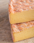 Pieces of cut gubbeen cheese on a wooden board.