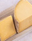 Large cuts of Hafod Cheddar on a wooden board.