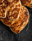 Pieces of fried halloumi on a slate platter.