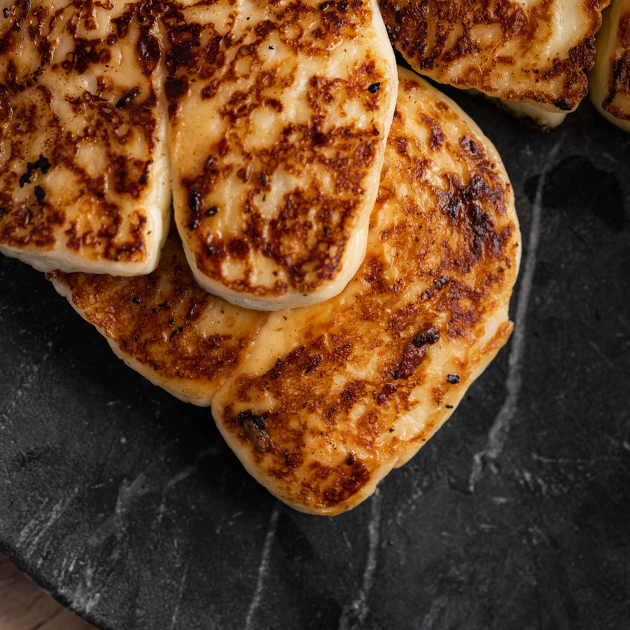 Pieces of fried halloumi on a slate platter.