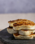 Pieces of fried halloumi stacked up on a slate platter.