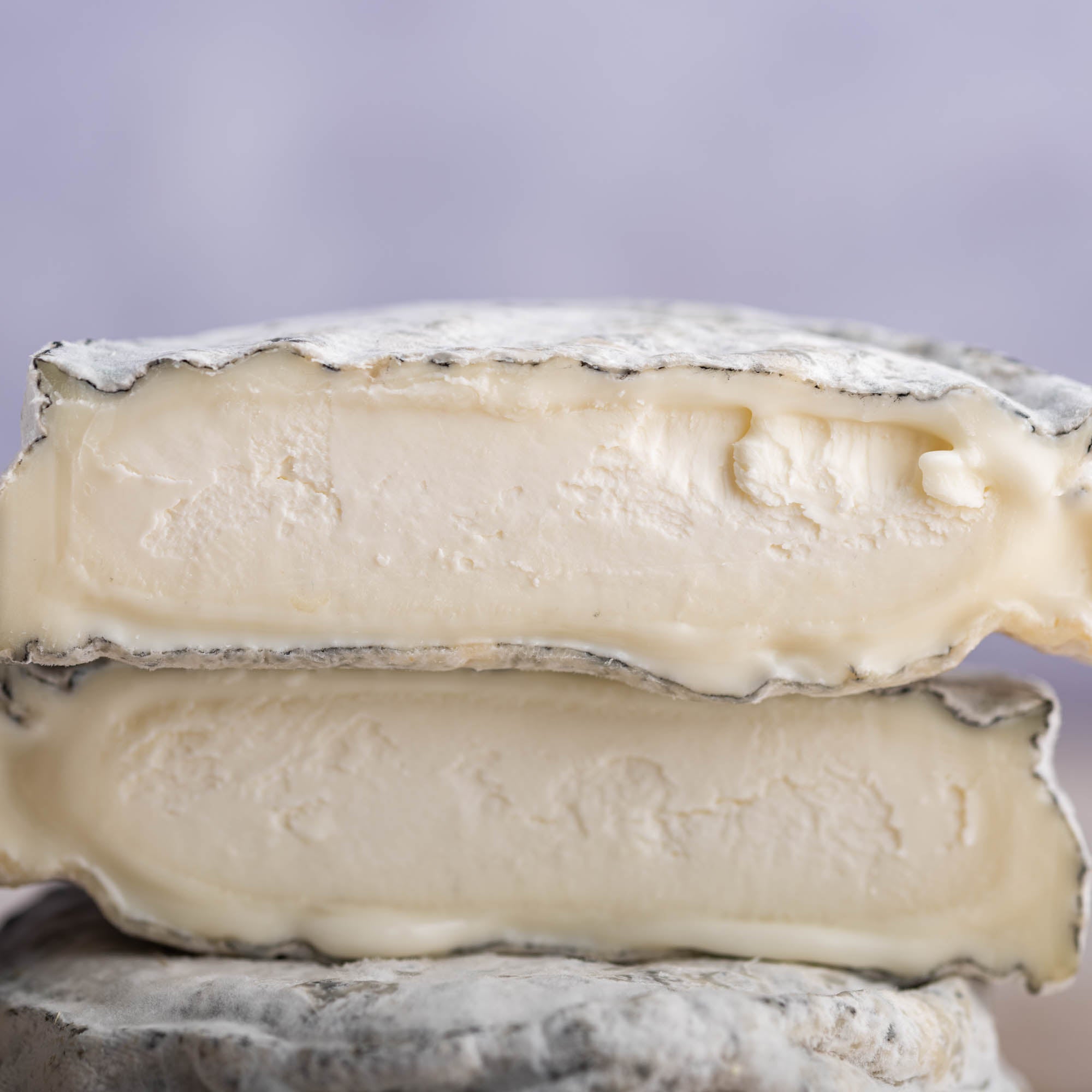 A close up photo of a two cut pieces of selles sur couffy goat's cheese.