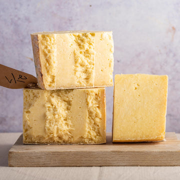 Pieces of Lancashire cheese on a wooden board.