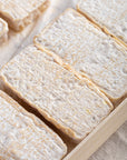 Whole Lingot des Causses goat's cheeses in a wooden box.