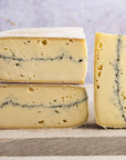 Cuts of morbier cheese arranged on a wooden board.