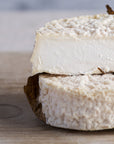 A Mothais sur Feuille goat's cheese on a wooden board.