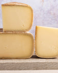 Cut pieces of ossau iraty cheese on a wooden board.
